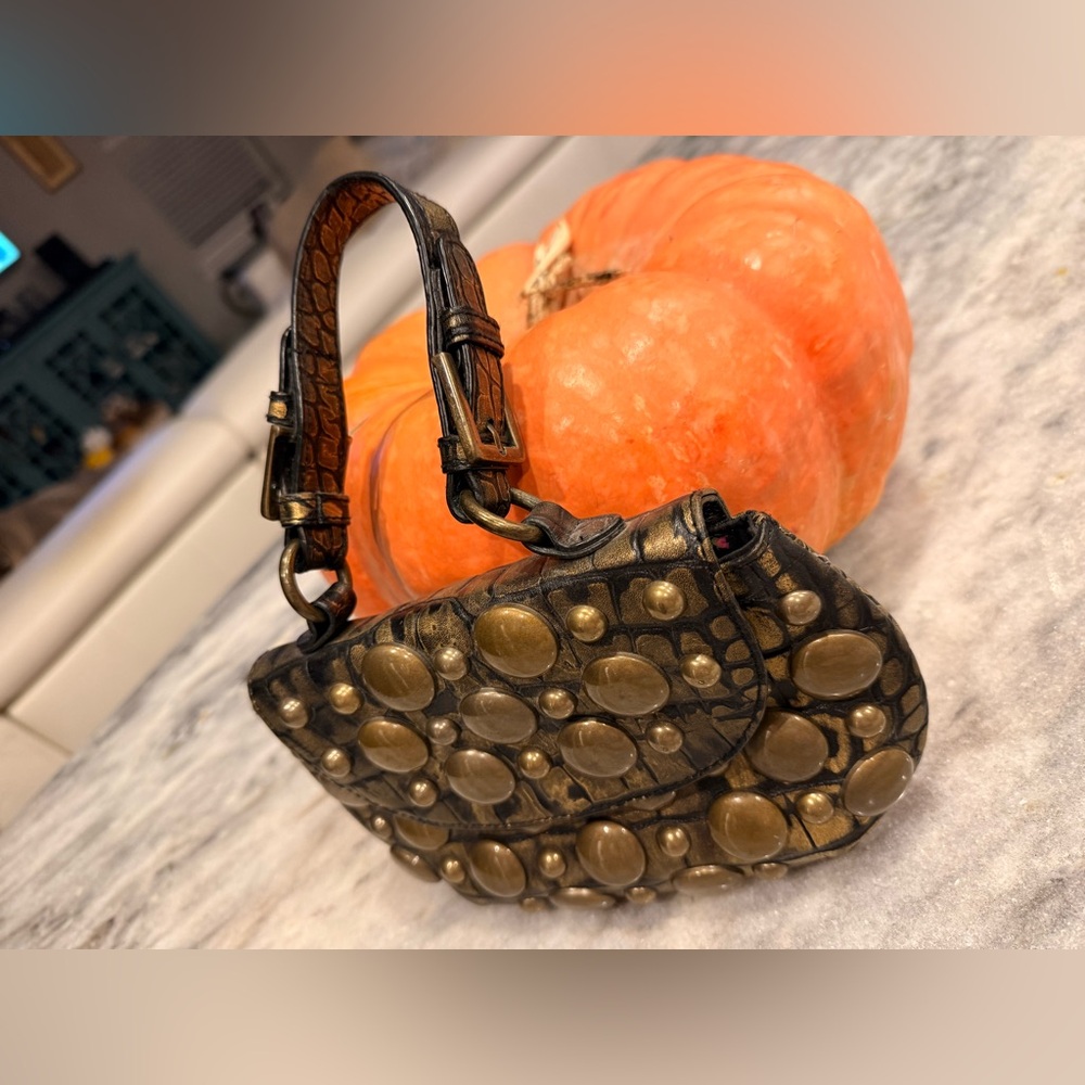 Rock out with this cool clutch by B. Johnson. Brass studs, faux alligator hide